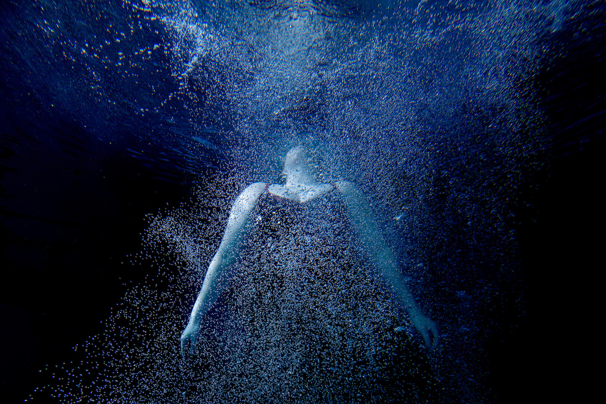 Person dancing underwater.