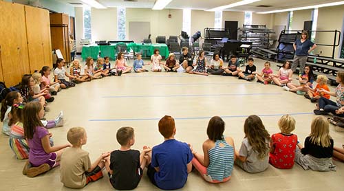 Students sit in a circle at Summer Music Week