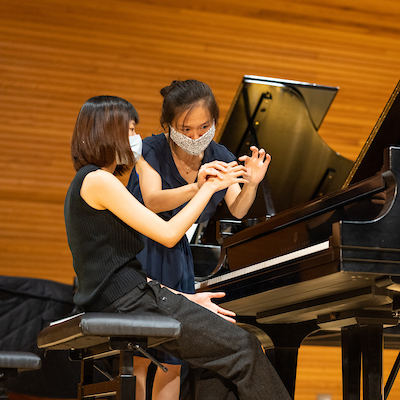 Visiting pianist Quing Jiang advises a piano masterclass student in Glidden Recital Hall.