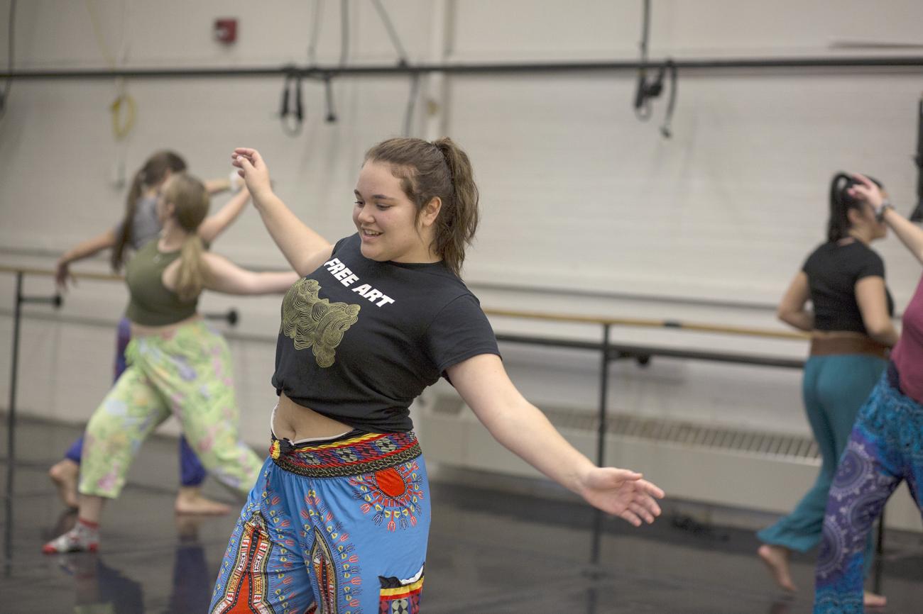 Student dances in class wearing a tshirt that says "free art"