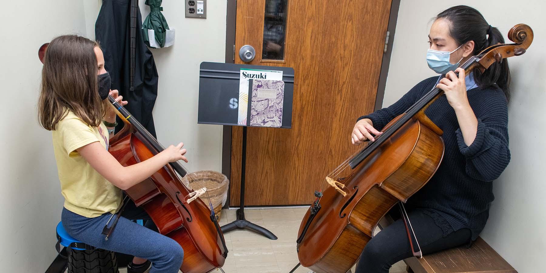 A student and instructor in a private cello lesson