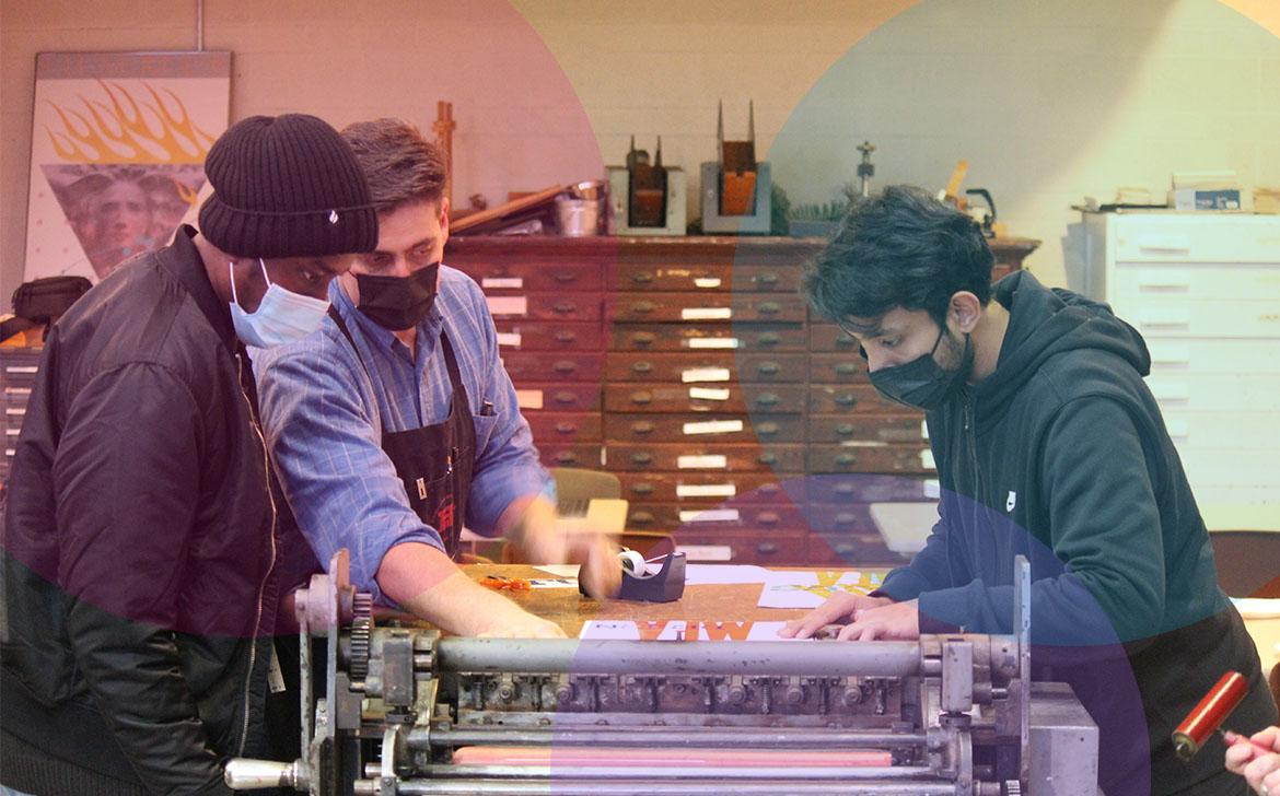 Students work at a machine.