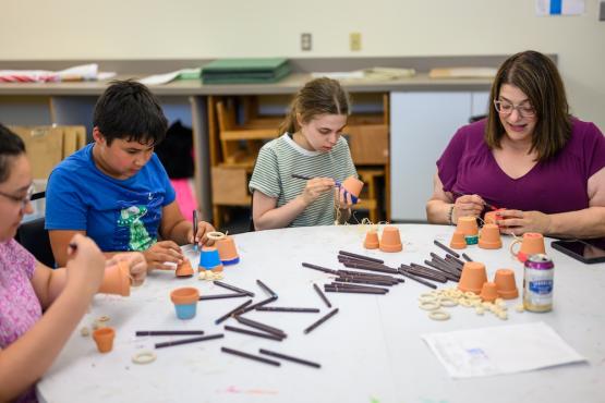 Jenna Messina sitting at a table painting with children