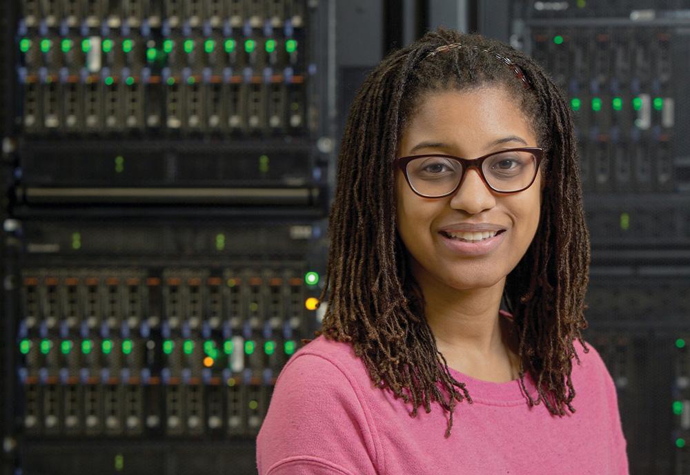 Payge Winfield poses in front of computer servers