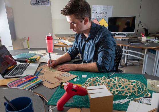 An architecture student works on a project at his desk