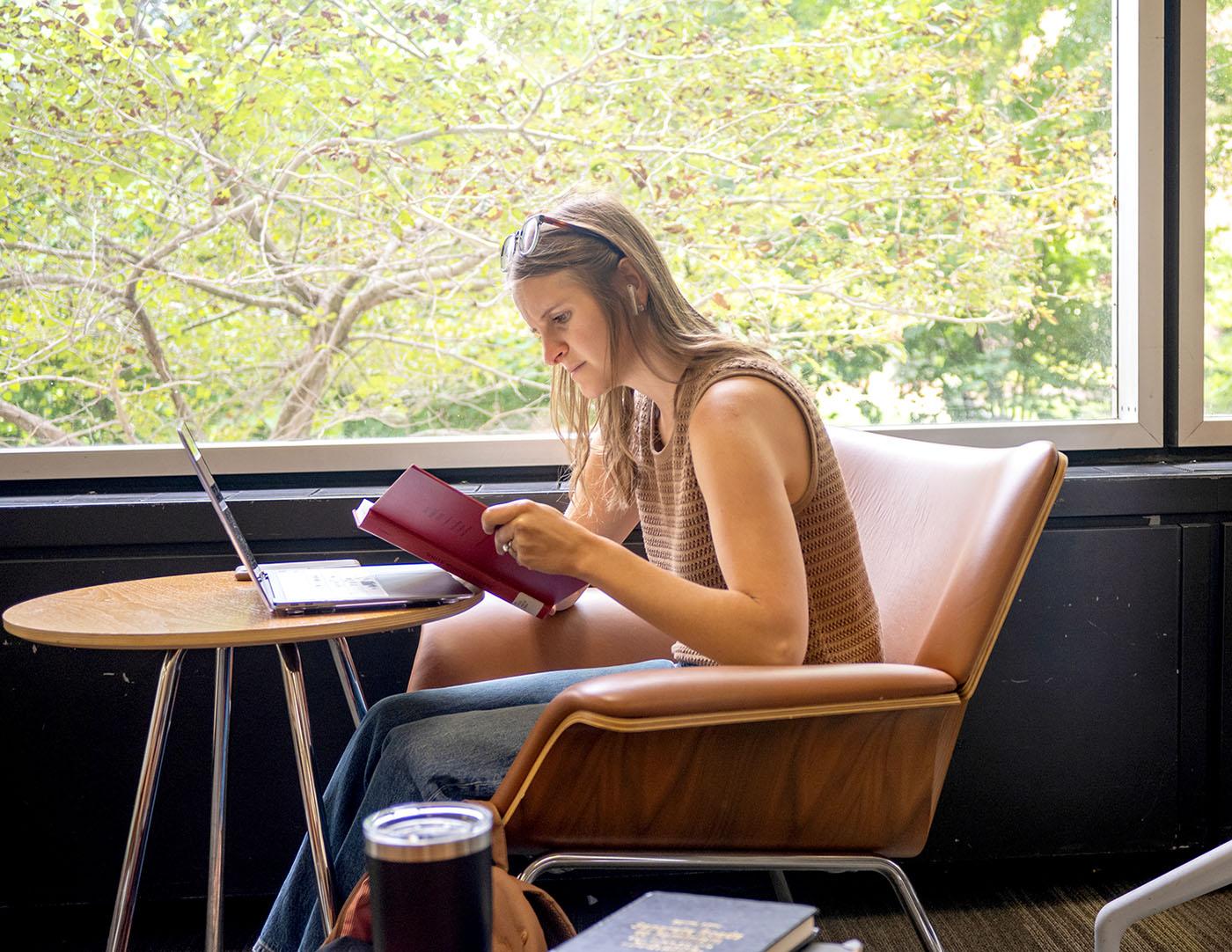 A female sitting at a table studying