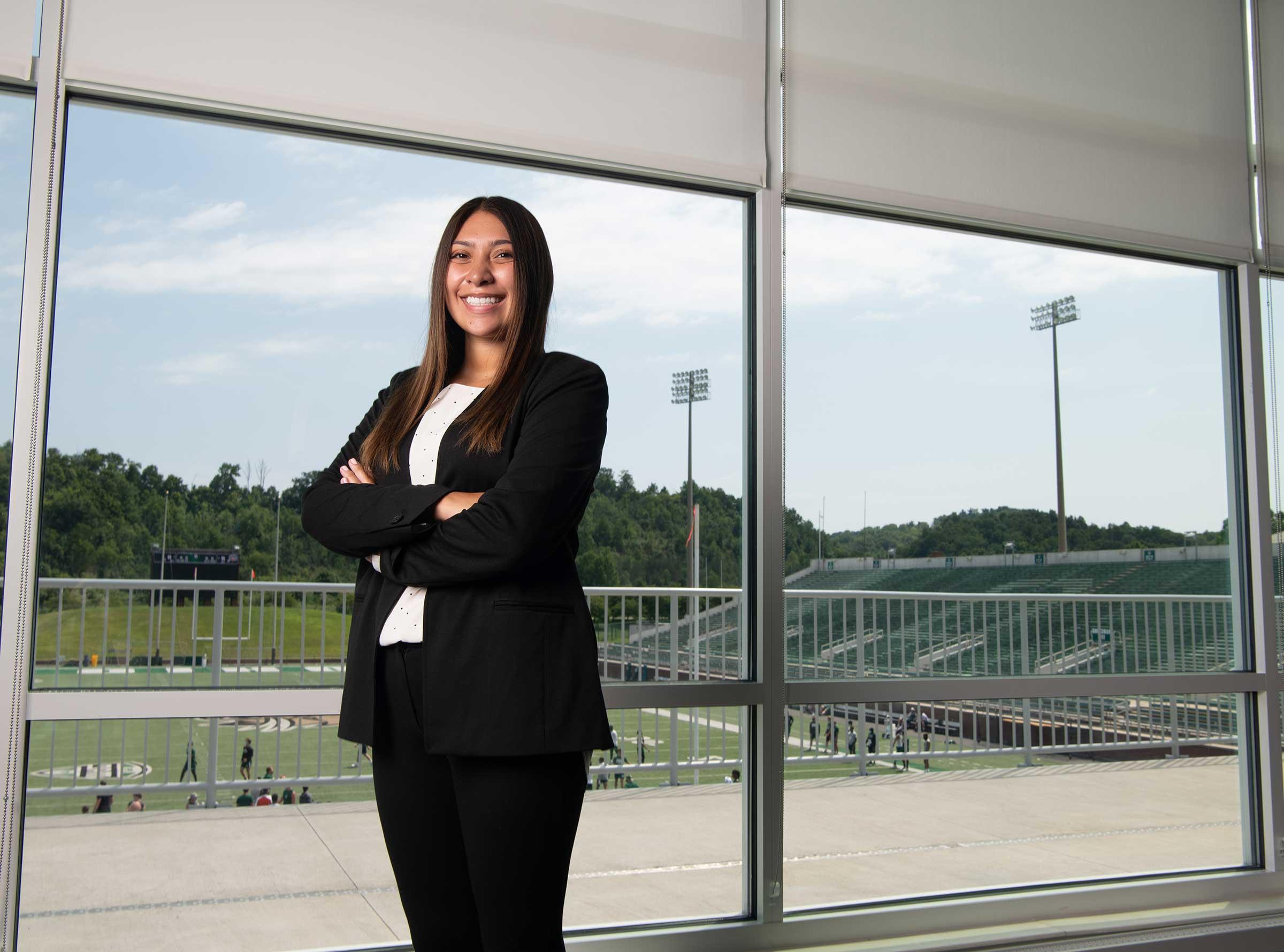 Sports administration student poses at Peden Stadium