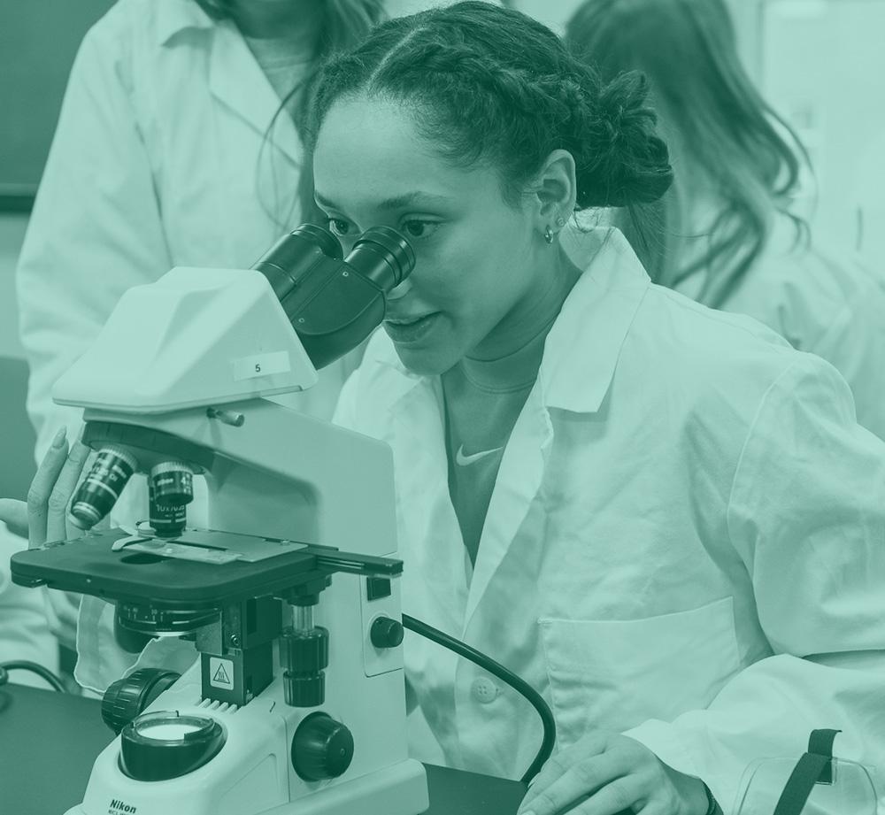A female student looking into a microscope