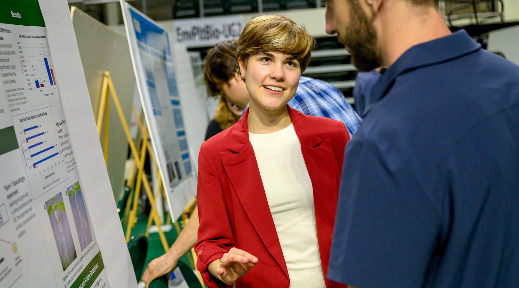 A woman talking with a man as they stand in front of display boards