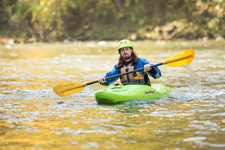 A male kayaking down a river