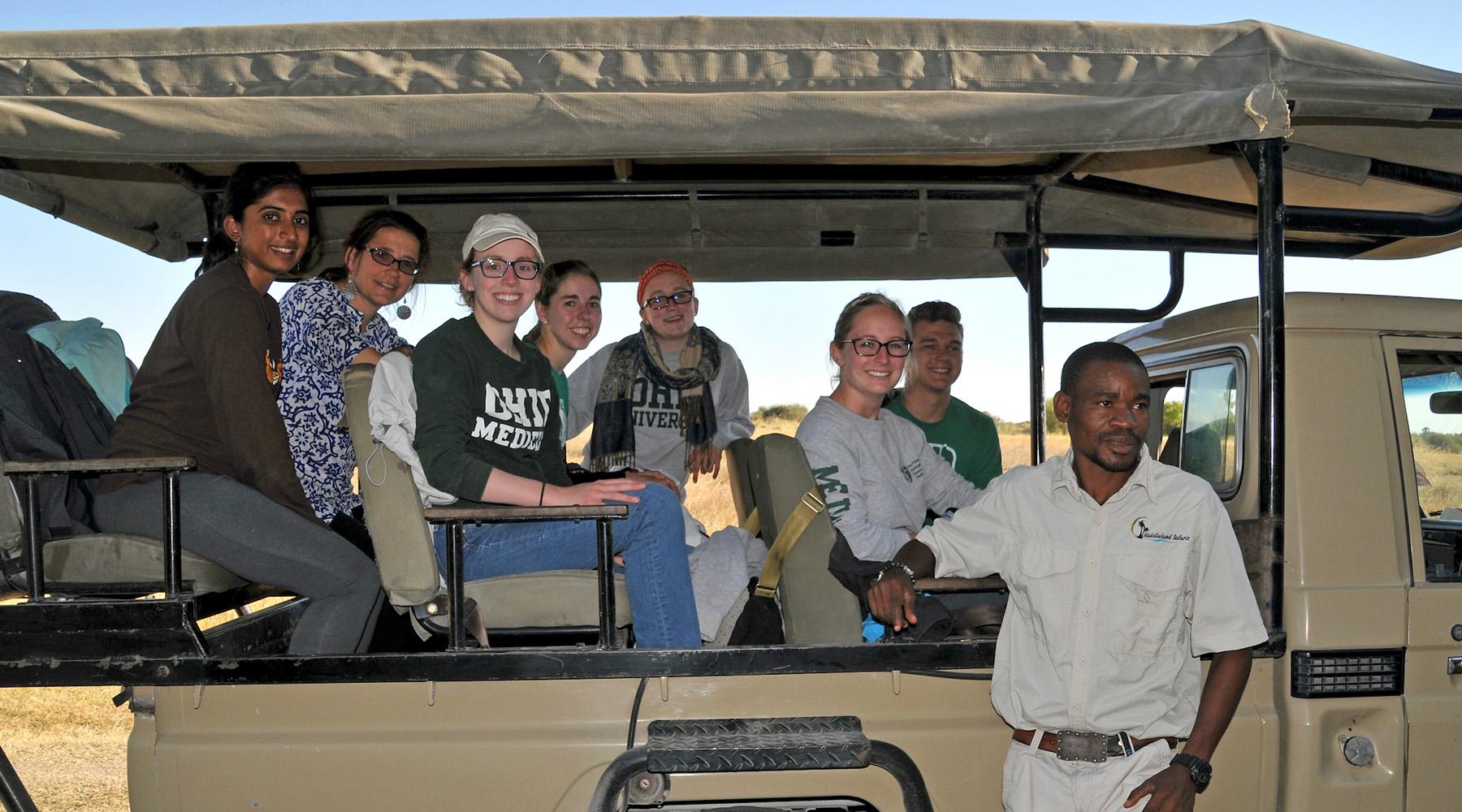 A group pose for a photo while in the back of a truck on a tour