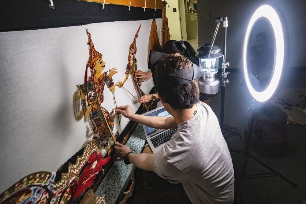 Backstage view of Southeast Asian shadow puppet performance