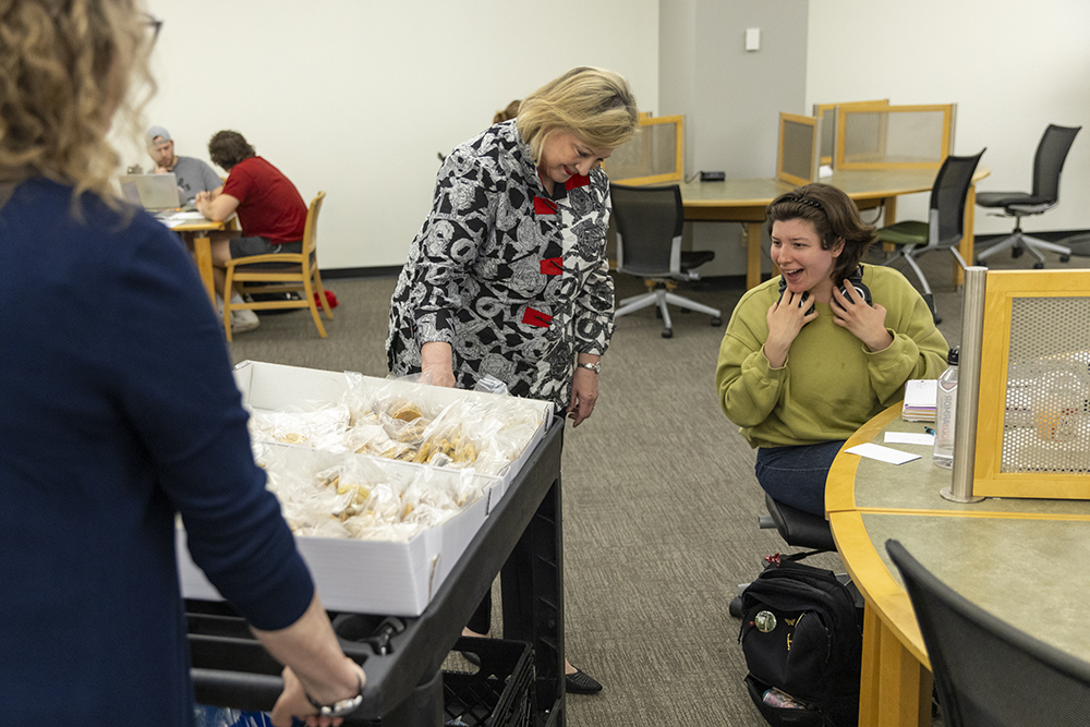 Photo of Ohio University President Lori Stewart Gonzalez giving cookies to student during finals.
