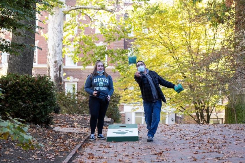 Father and daughter playin corn hole at the Alden Open Mini Golf event