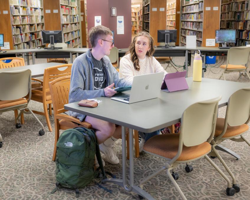 Two students work together at a table in the Eastern Campus Library