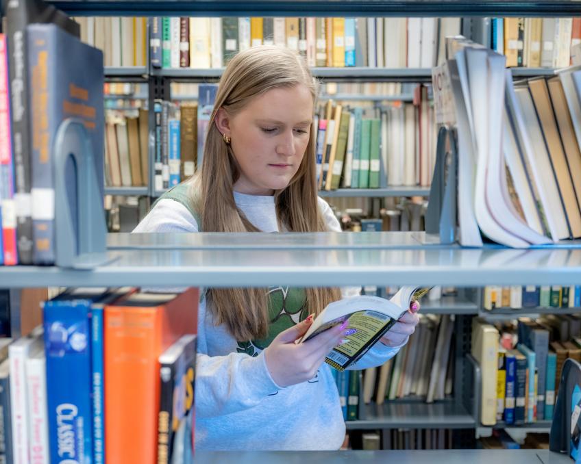A student browses book stacks at the Lancaster Campus Library