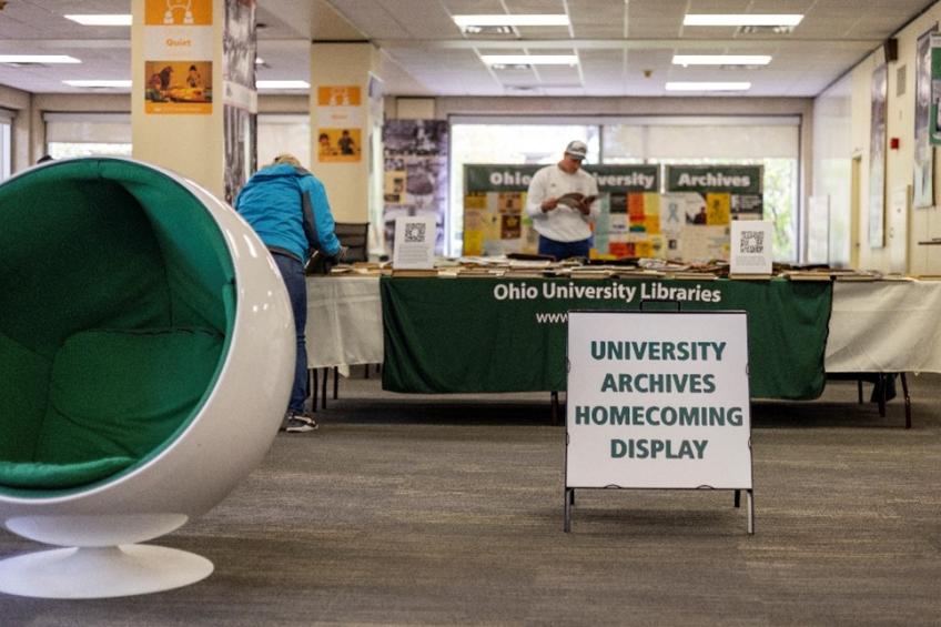A sign reading UNIVERSITY ARCHIVES HOMECOMING DISPLAY stands in front of a table full of books