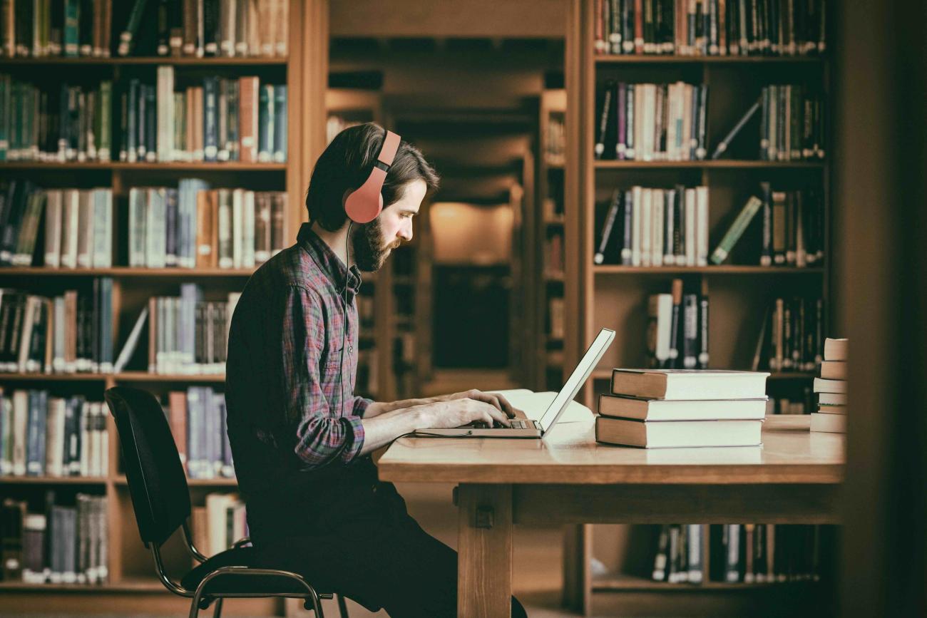 Student studying on their laptop in the library