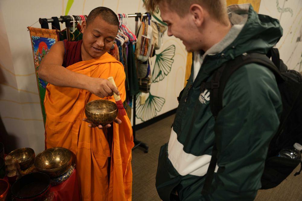 Tenpa Thapkhey, a Tashi Kyil Monk, gives Sammy Artino, freshman, a singing bowl
