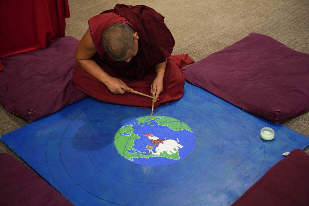 Tenpa Thapkhey of the Tashi Kyil Monastery creates a globe out of sand