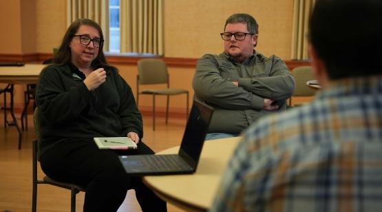 GIS analyst Jessica Schaudt and GIS manager Trevor Flint speak with attendees while seated