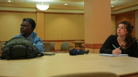 A man and a woman sit taking notes during the GIS Day workshop event at Baker Center