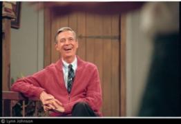 An image from the Lynn Johnson Collection: Fred Rogers laughs in the living room set of Mister Rogers' Neighborhood in WQED studio, 1992