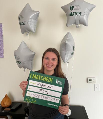 Graduate Meghan Trout holds Match Day sign