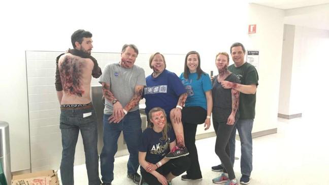 A group of 7 standardized patients pose for a photo