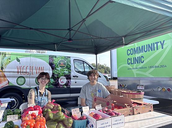Two people with vegetables at farmers market