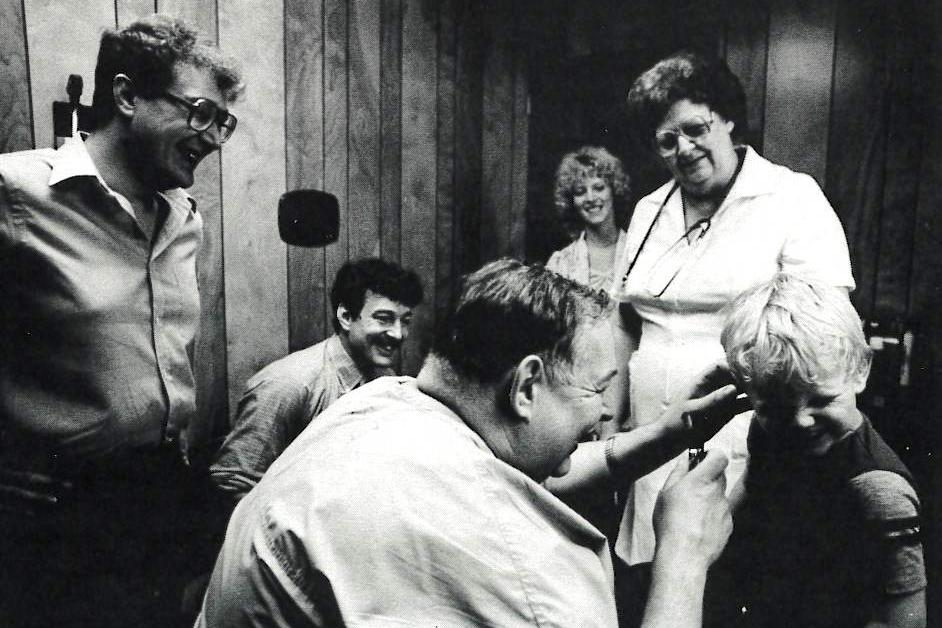 Walter Wagner treats young Joshua McCue while Mark, his older brother Peter, Loretta McCue and nurse Ada Irvan look on.