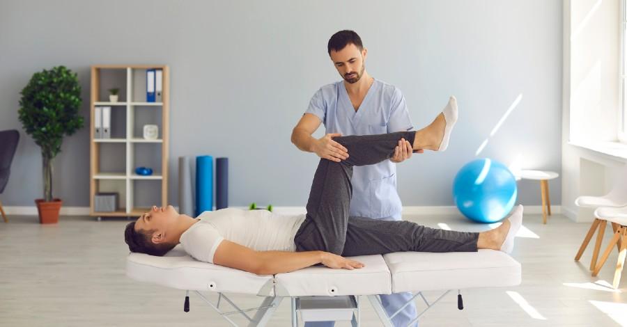 man laying on exam table with osteopathic doctor evaluating the patient