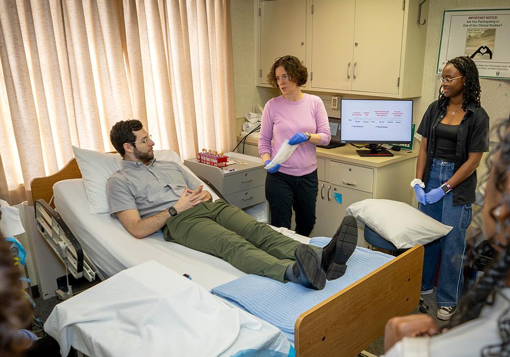 A man lays on a medical bed in a hospital room while being treated 