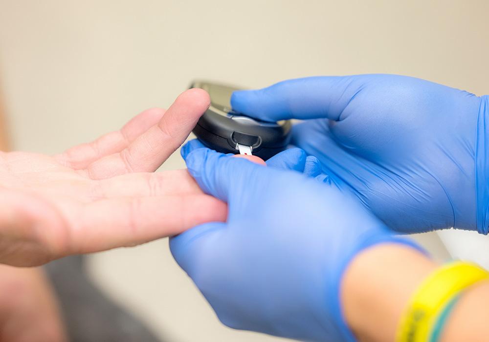 An up close picture of someone getting their blood sugar tested via a finger prick