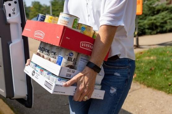 Heritage College Events Manager Carolyn Ervin unloads items from donors' vehicles.