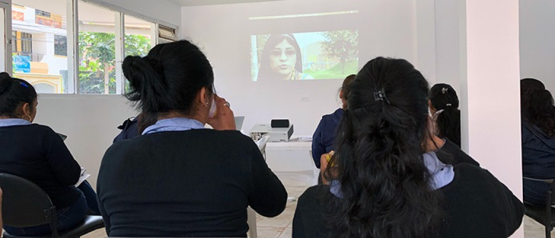 Students listen while watching a presentation on a projector