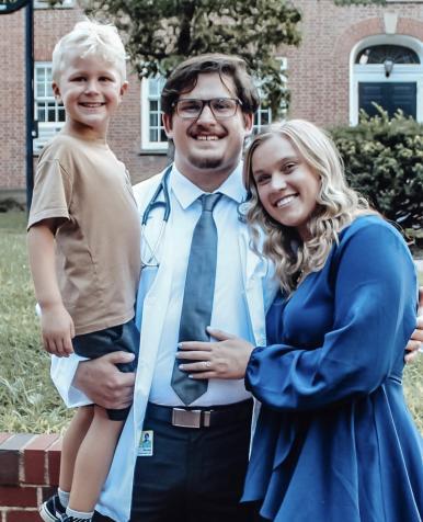 A picture of Nicolas Suglio in his white coat, with his family.