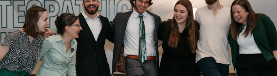 Students and staff standing side by side laughing