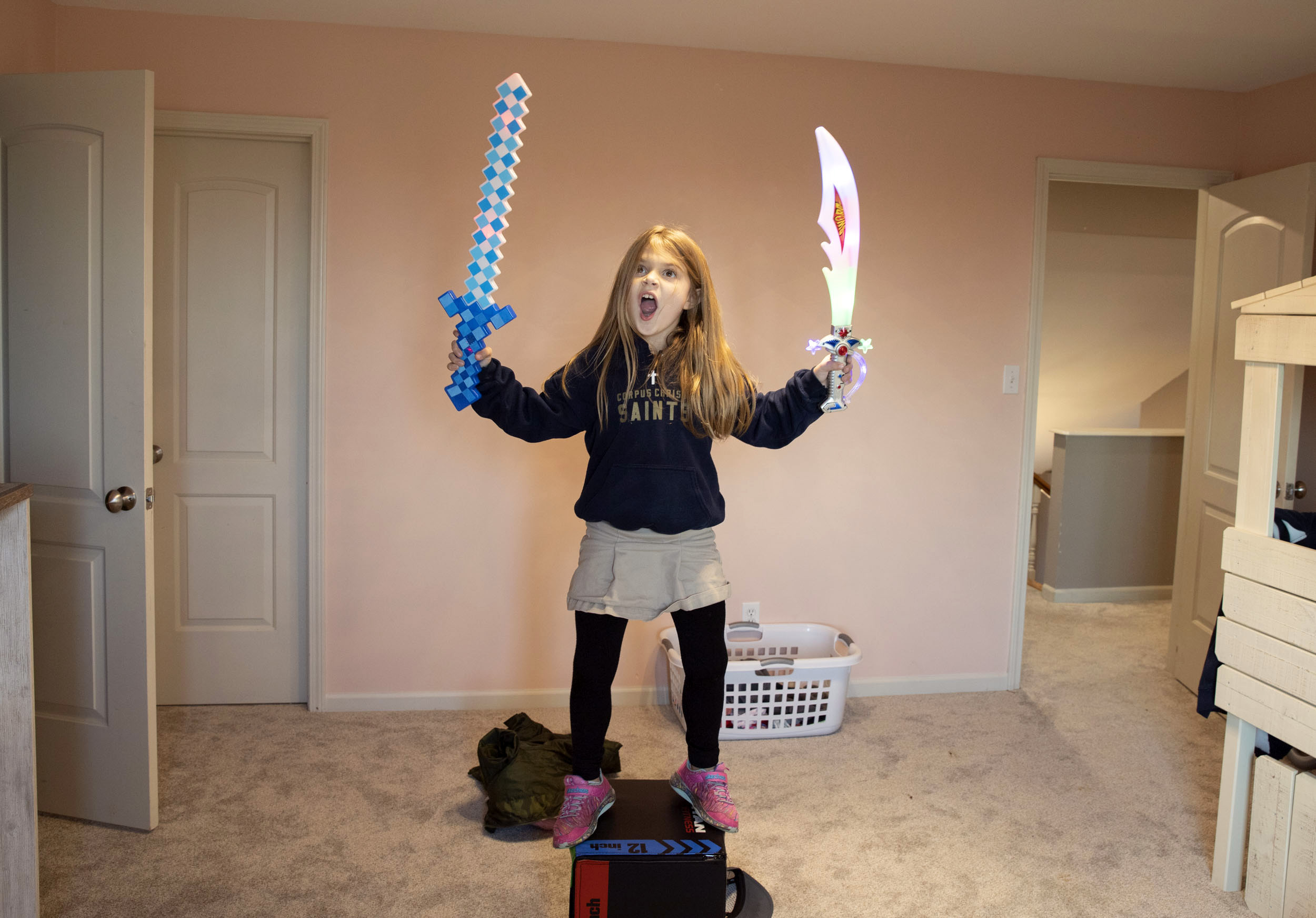 Young girl poses with toy swords
