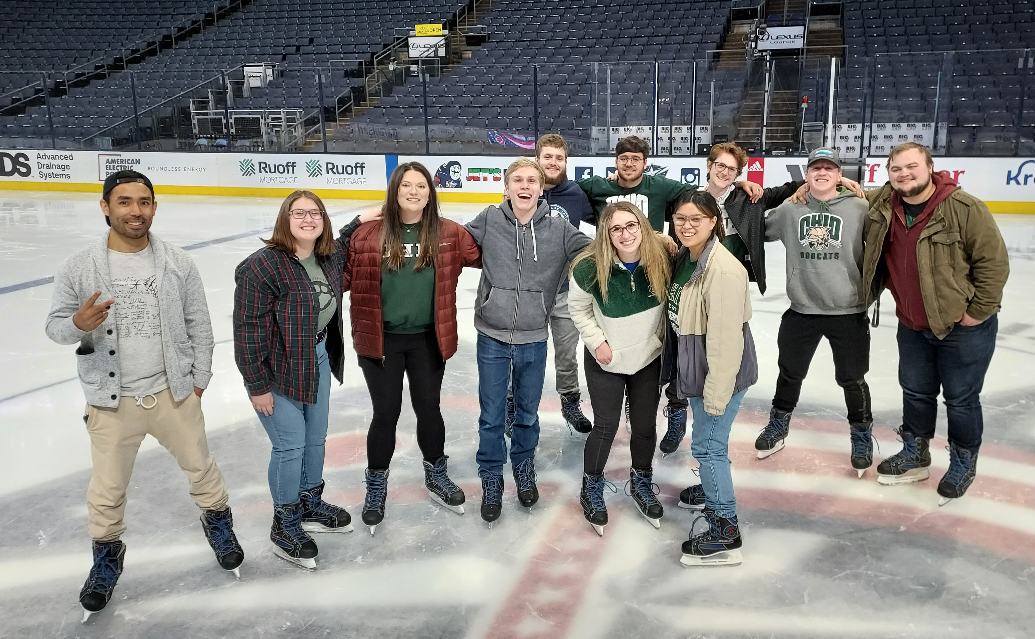 A group of Media Arts and Studies students pose on the Columbus Blue Jackets' ice rink