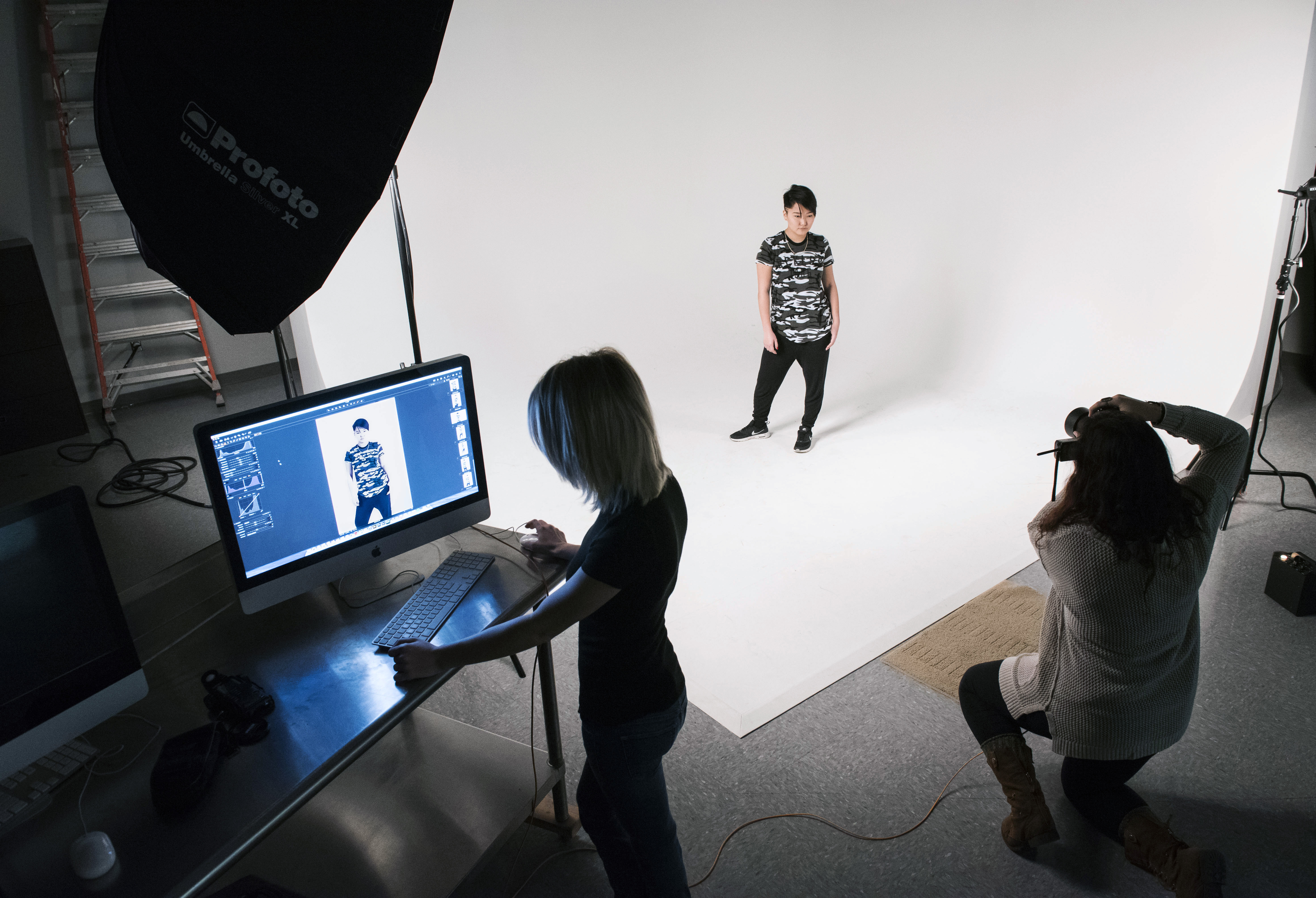 photographer shooting a model in a professional photography studio