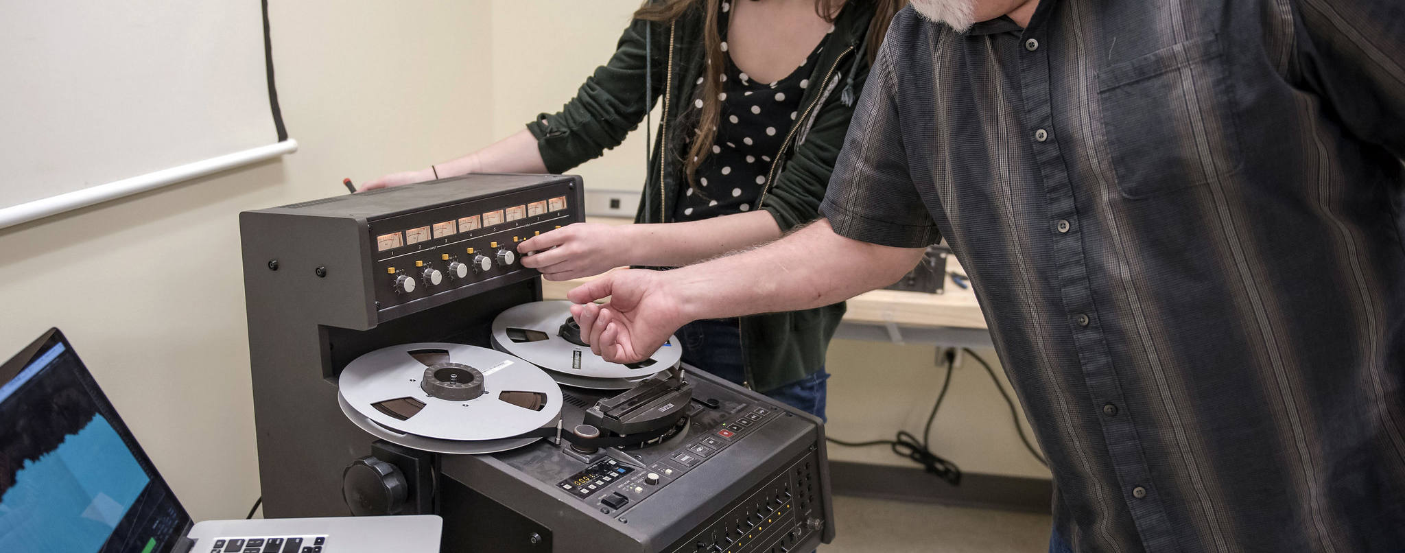 Jeff Redefer teaching student how to use a tape machine