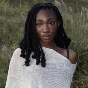 Photo of Leticia Oteng sitting in a field