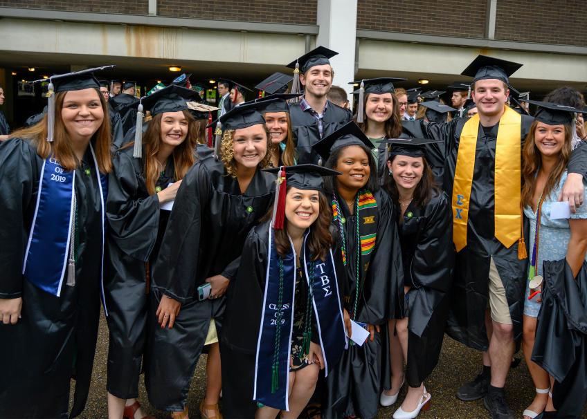 2019 Scripps College of Communication graduates pose happily in their caps and gowns