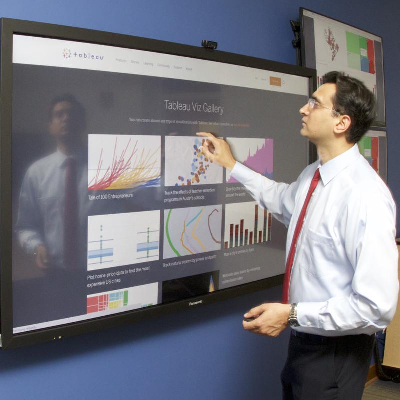 Professor Laeeq Khan in the SMART Lab explaining charts on screen