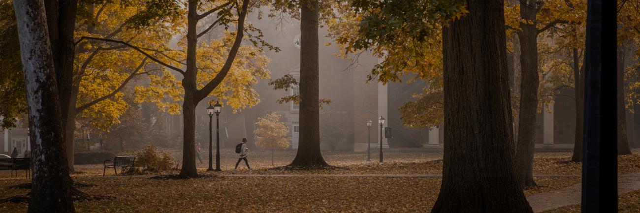 A student walks across Ohio University's College Green