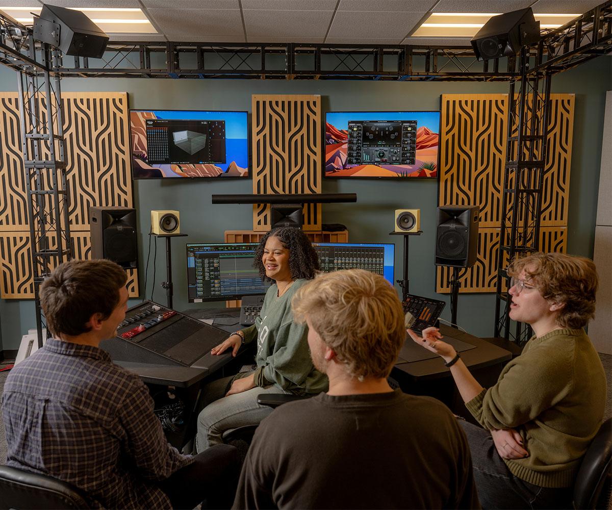 Students talk and share ideas in a mixing studio.