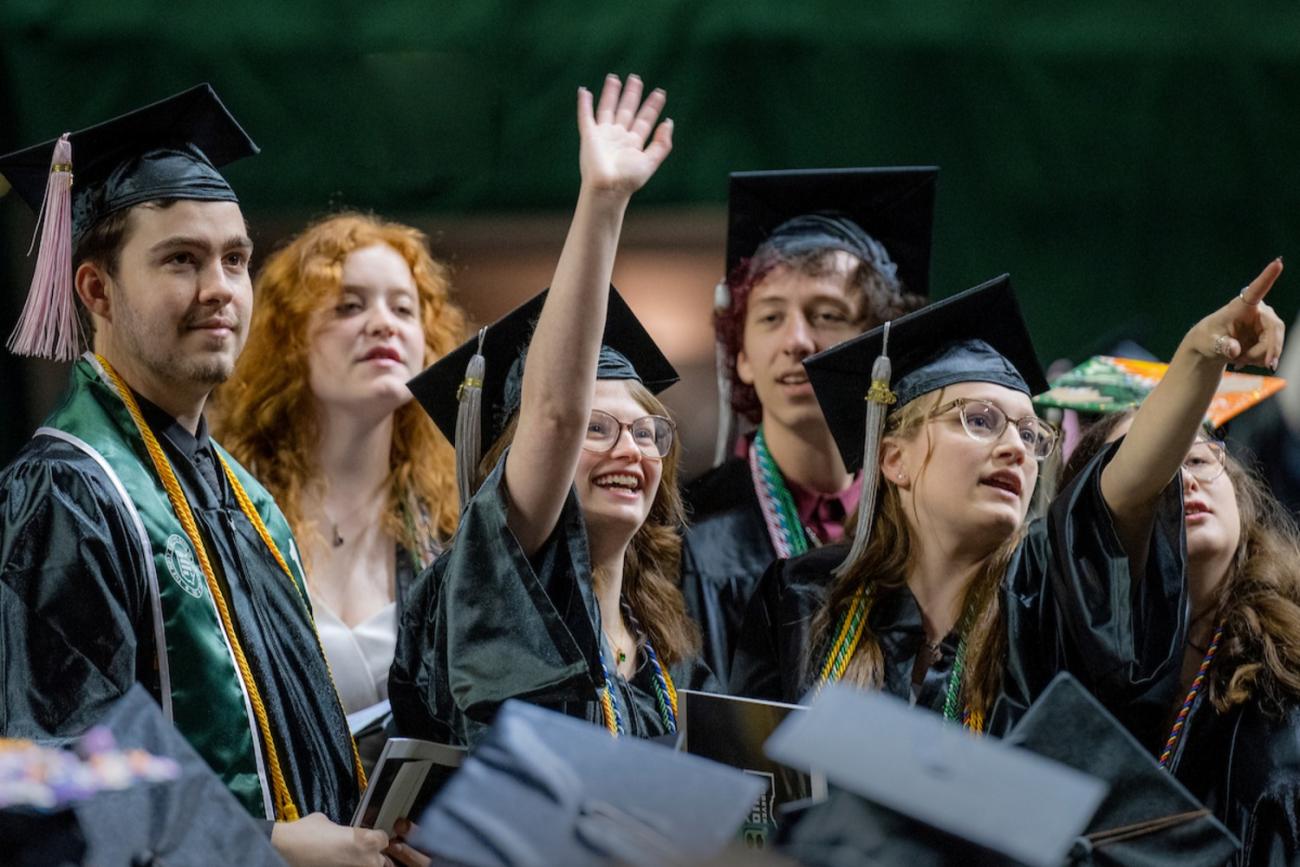 Students of Scripps College of Communication at graduation waving to family