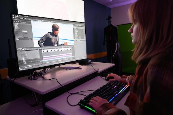 A student works on a computer in the video editing visualization lab
