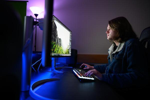 A student works on a computer in the video editing visualization lab